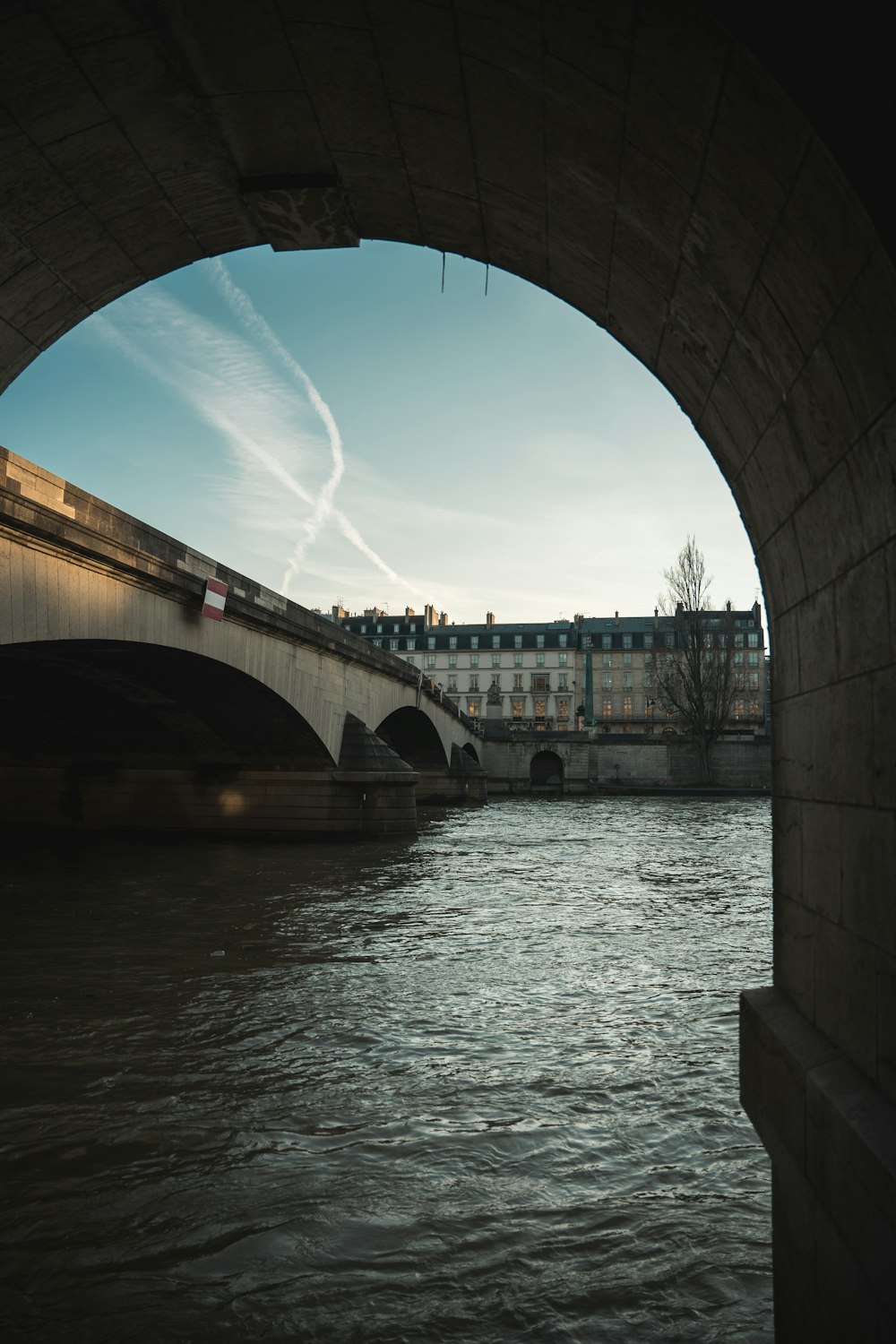 a bridge over a body of water with a building in the background