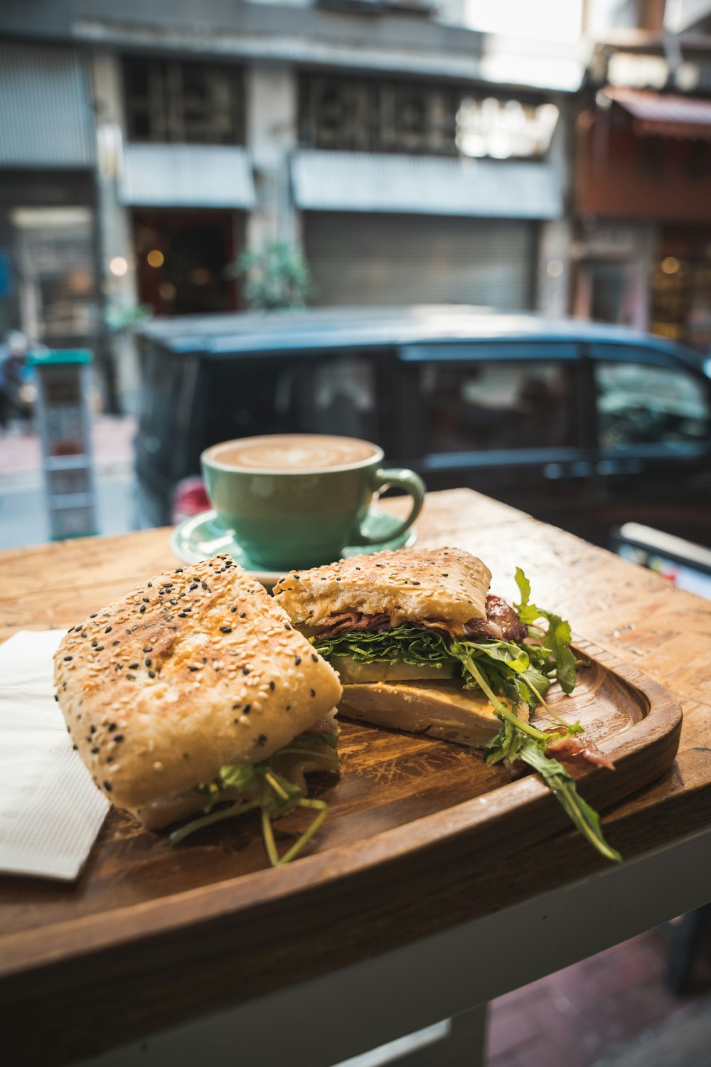 ein Holztisch mit einem Sandwich und einer Tasse Kaffee