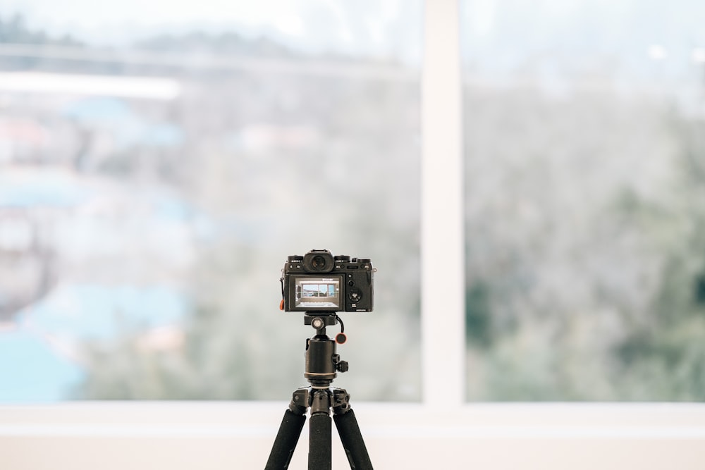 a camera on a tripod in front of a window