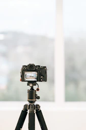 a camera on a tripod in front of a window