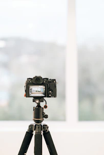 a camera on a tripod in front of a window