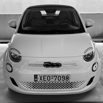 a small white car parked in a parking lot