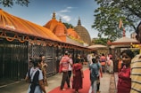 Family walking together on a temple pathway adorned with marigold garlands.