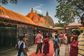 Family walking together on a temple pathway adorned with marigold garlands.
