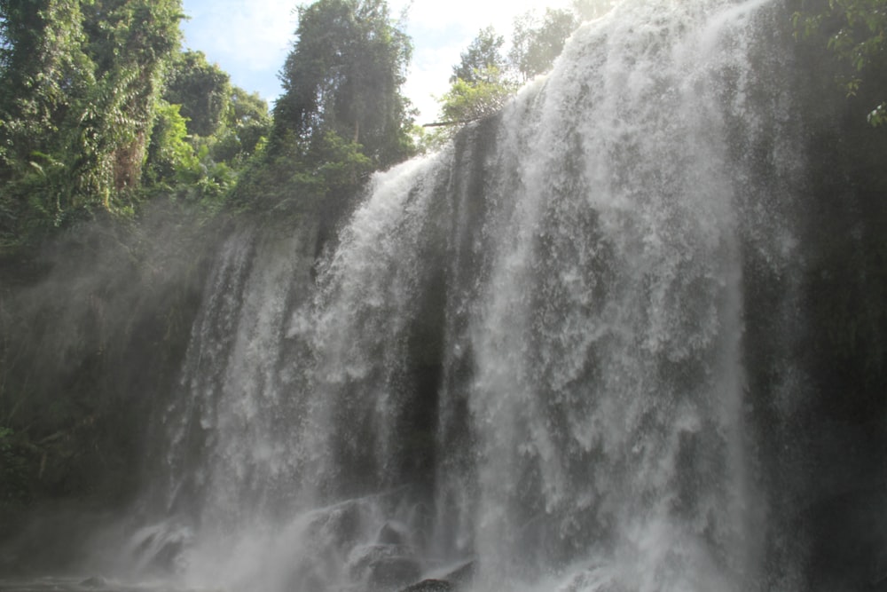 a large waterfall in the middle of a forest