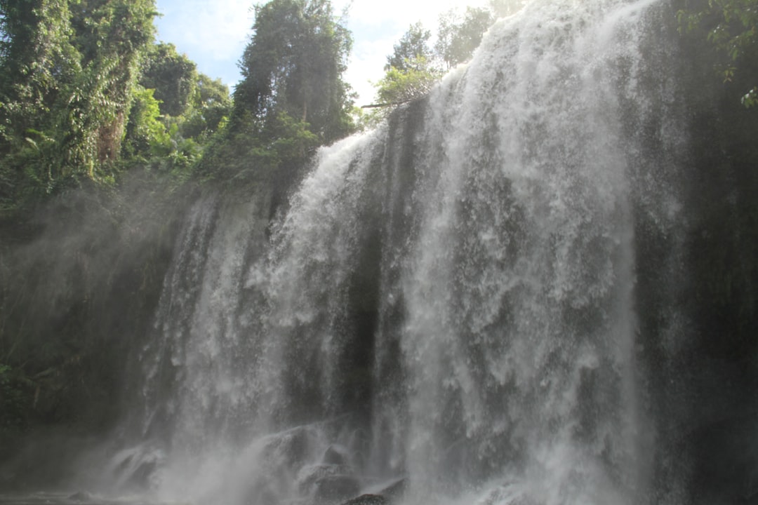 a large waterfall in the middle of a forest,