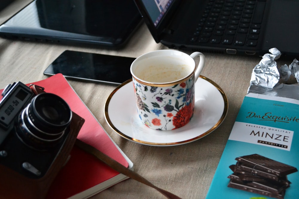 a cup of coffee sitting on a saucer next to a book