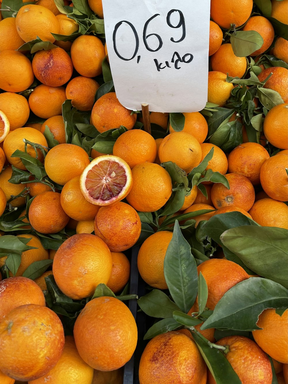 a pile of oranges with a price sign on them