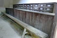 Rustic dining bench with built-in storage drawers beneath a farmhouse table.