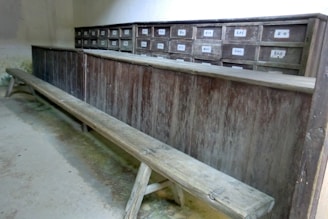 Rustic dining bench with built-in storage drawers beneath a farmhouse table.