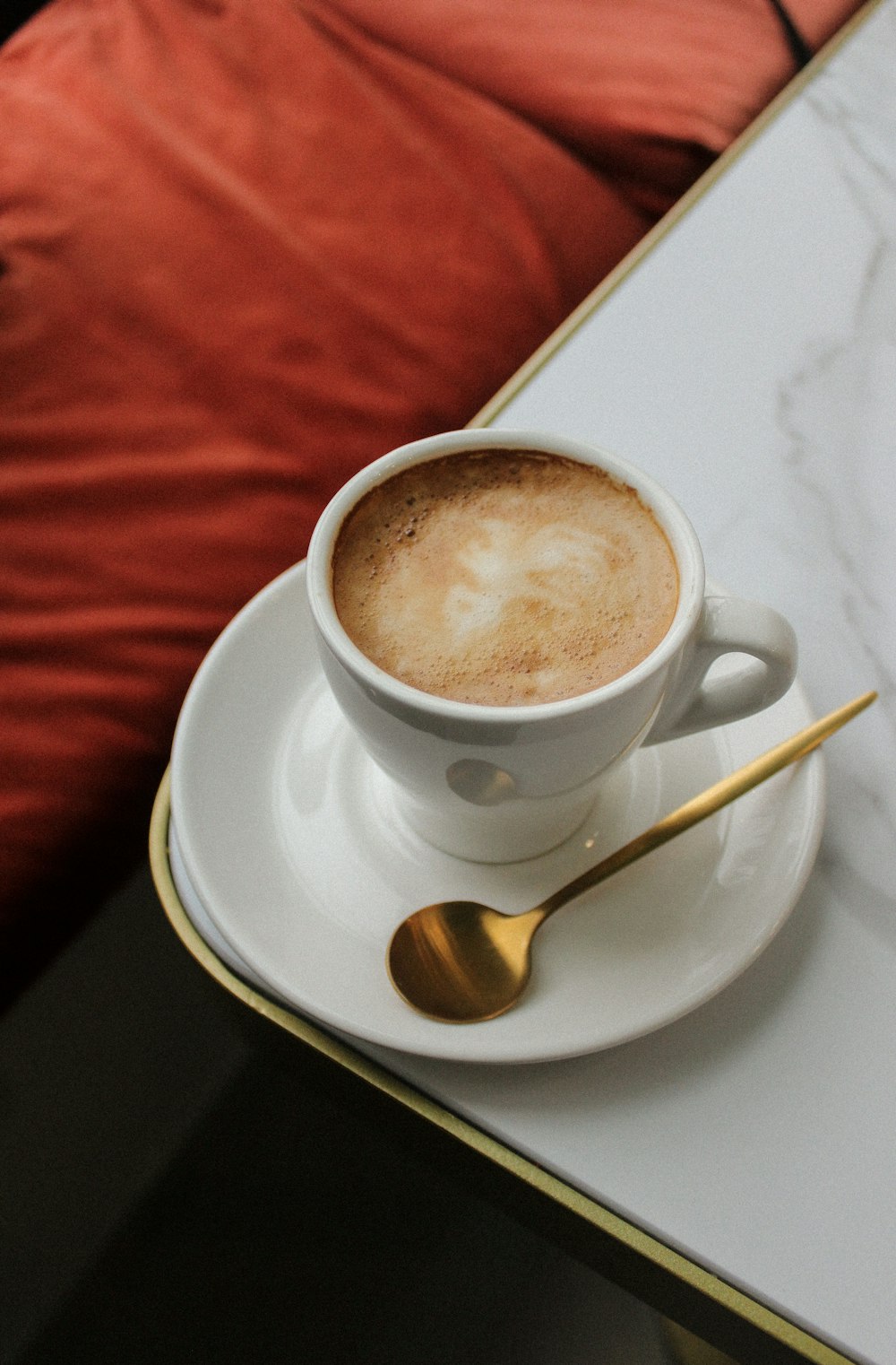 a cup of coffee on a saucer with a spoon