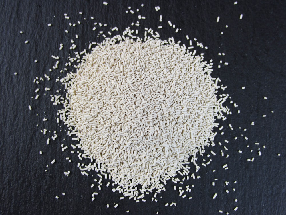 uma pilha de arroz branco sentado em cima de uma superfície preta