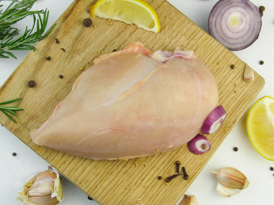 Pechuga de pollo cruda sobre una tabla de cocina