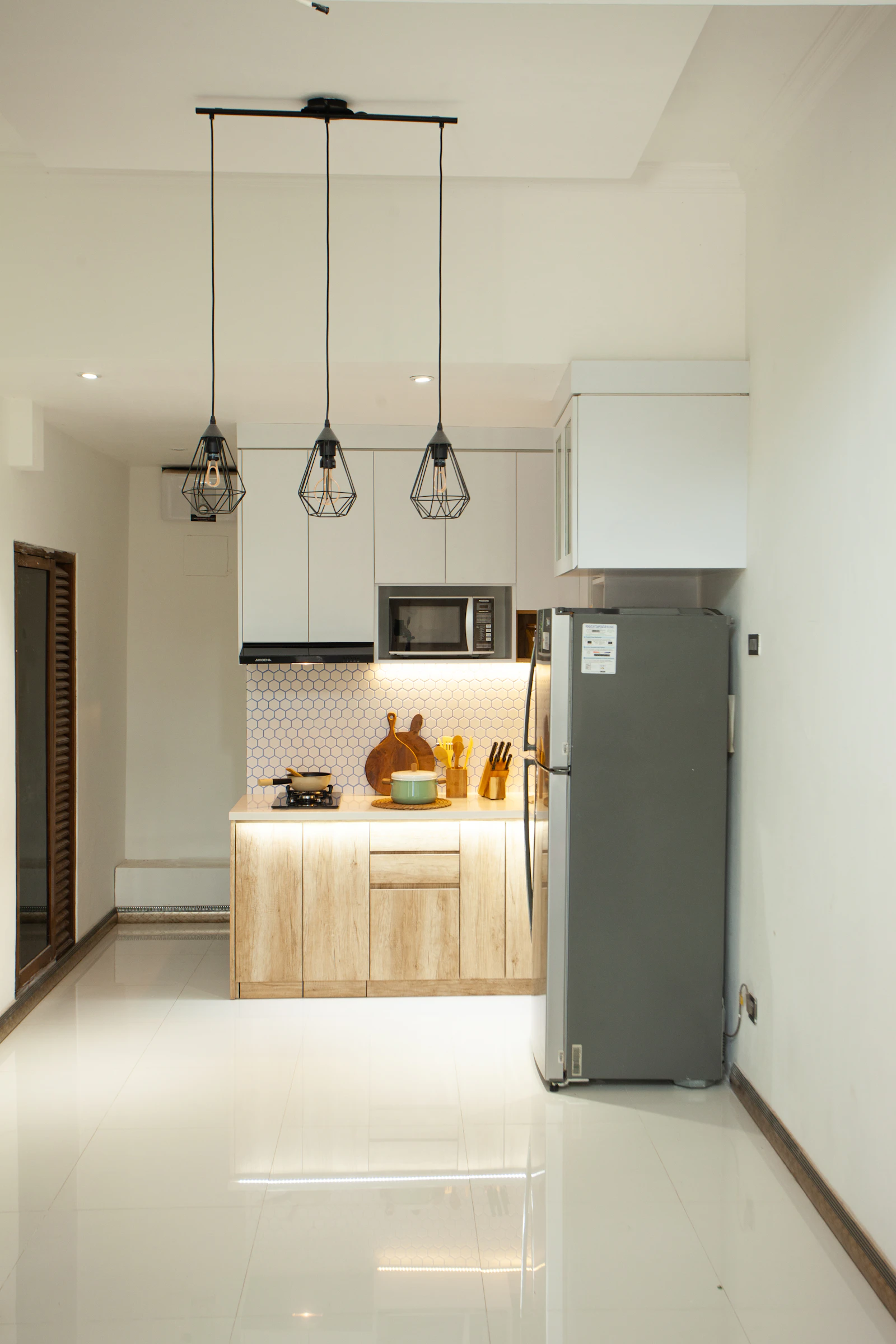 A compact kitchen and living space in warm neutral tones