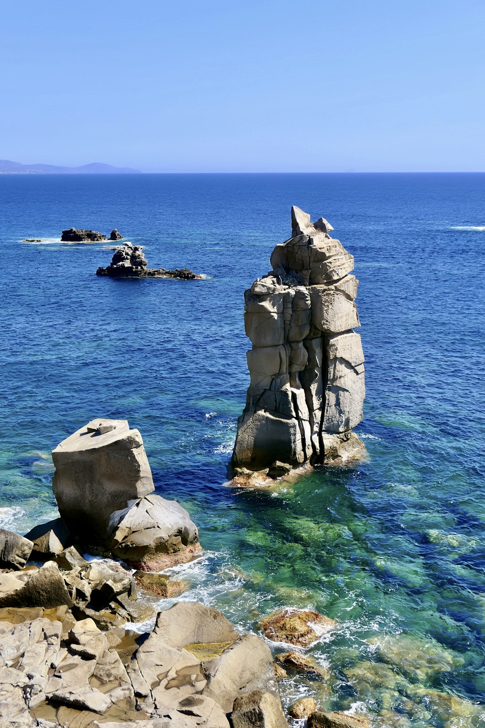 a large rock formation in the middle of a body of water