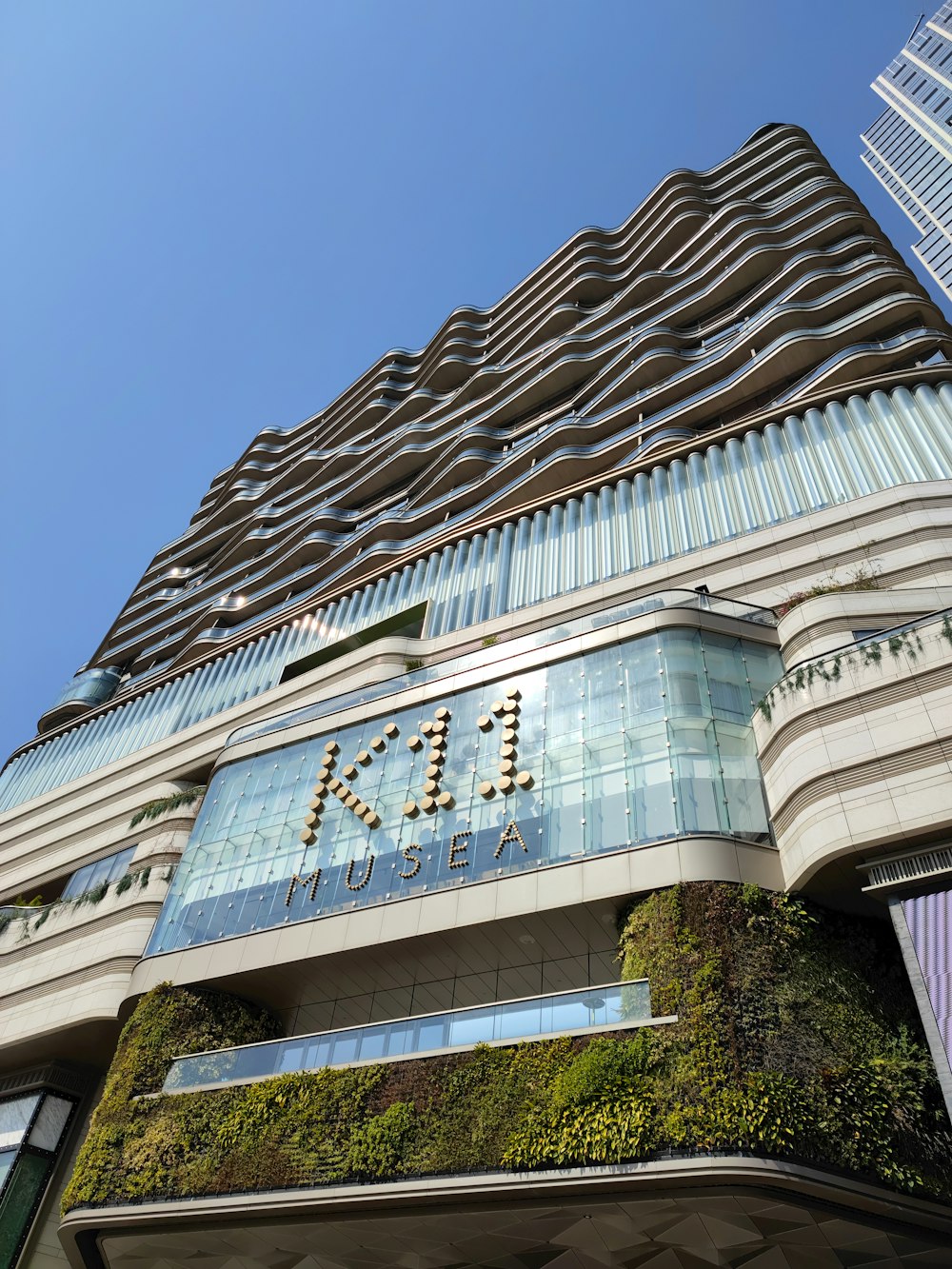 a tall building with a green plant growing on the side of it