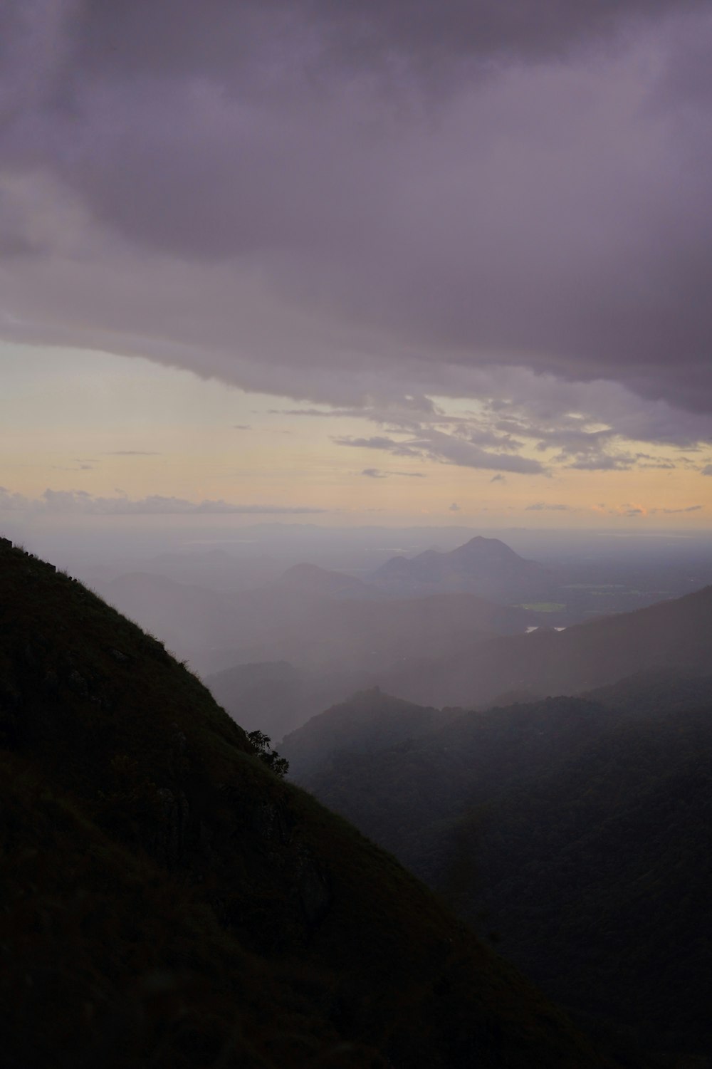 a person standing on top of a hill under a cloudy sky