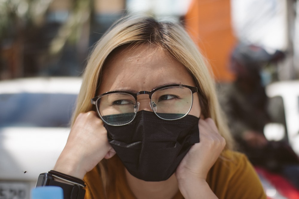 a woman wearing glasses and a black face mask