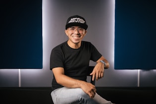 a man sitting on top of a black couch