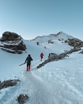 a group of people hiking up a snow covered mountain