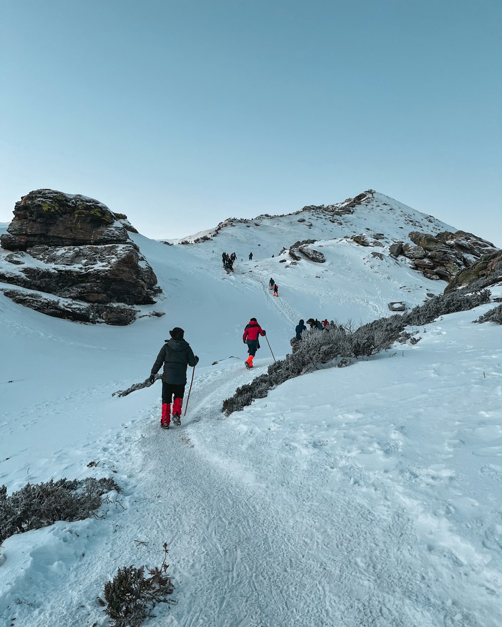 a group of people hiking up a snow covered mountain