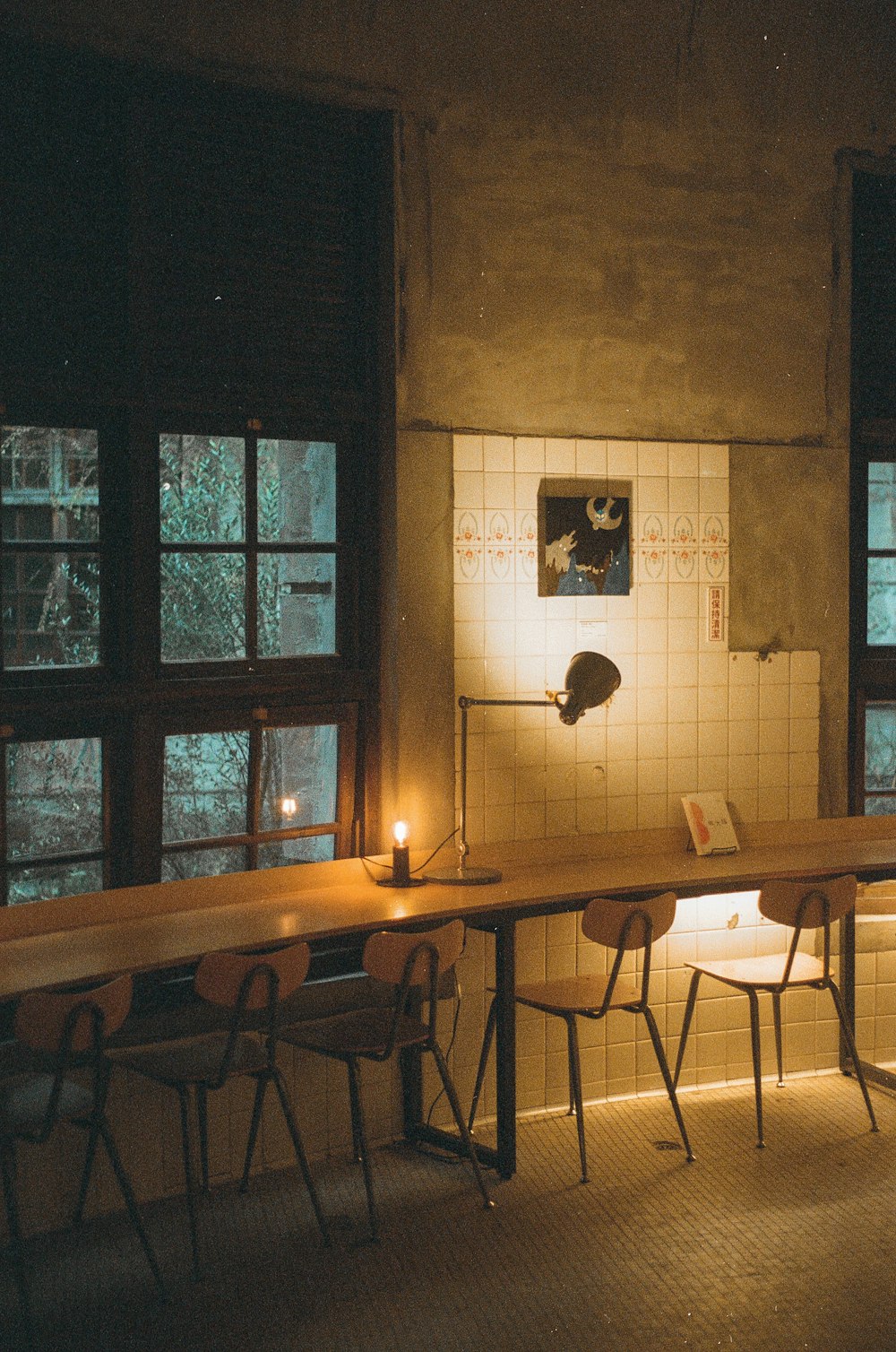 a room with a table, chairs and a lamp