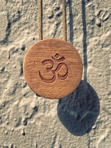 a wooden sign hanging from a rope on a wall