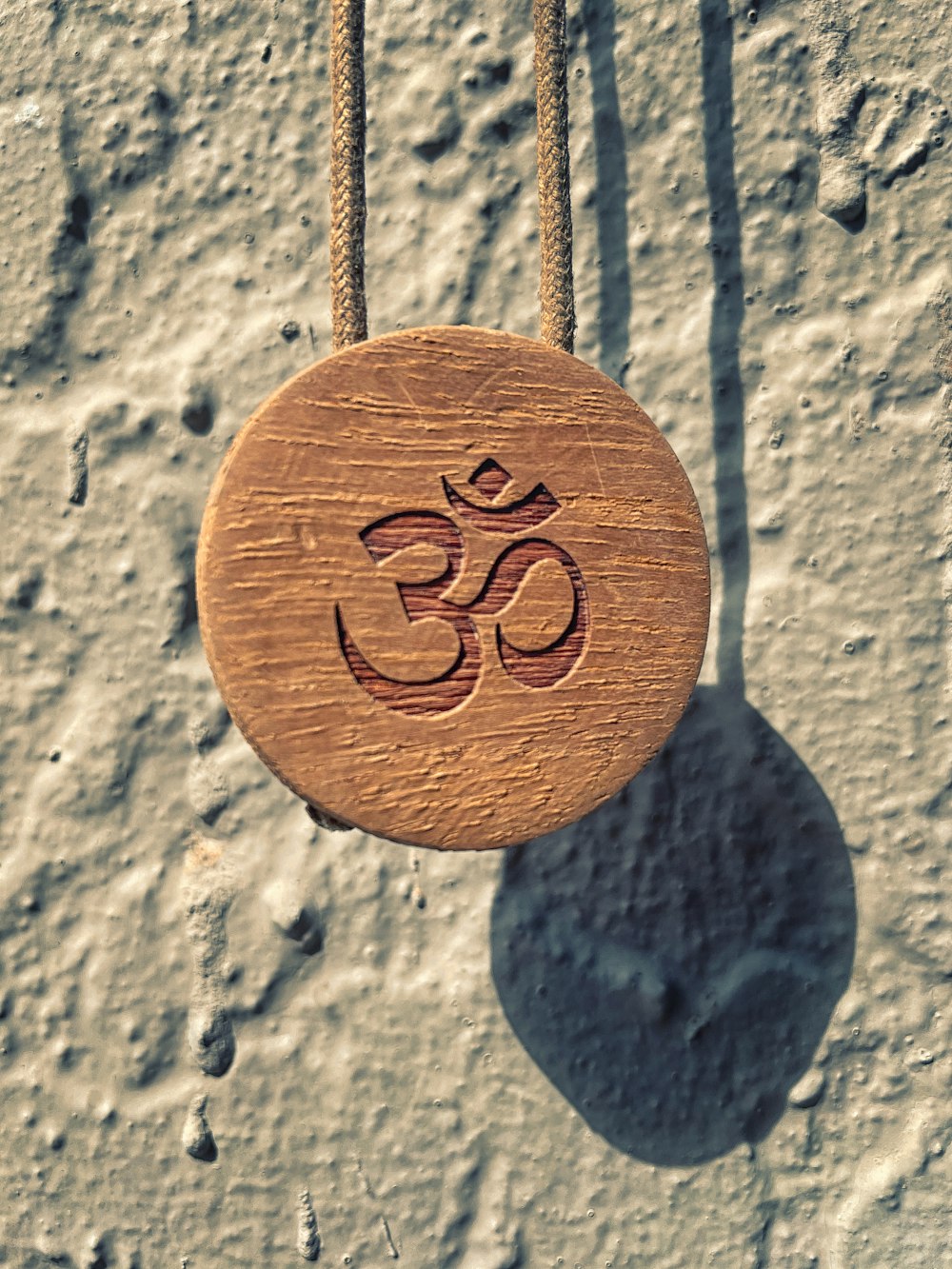 a wooden sign hanging from a rope on a wall