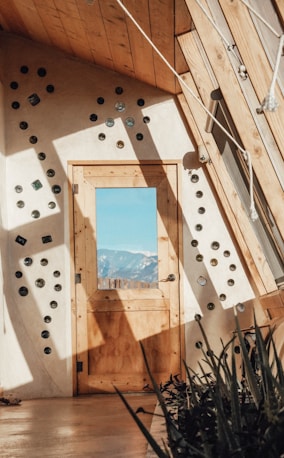 a wooden door sitting inside of a room next to a window
