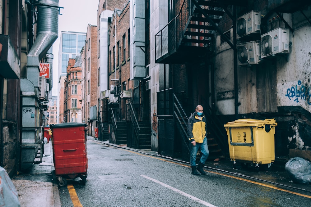 a man in a yellow jacket is walking down the street