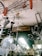 Numerous metallic antennas and fans are hanging from the ceiling of a shop. The items appear to be stacked closely together, creating a cluttered visual effect. There is a signboard partially visible in the background.