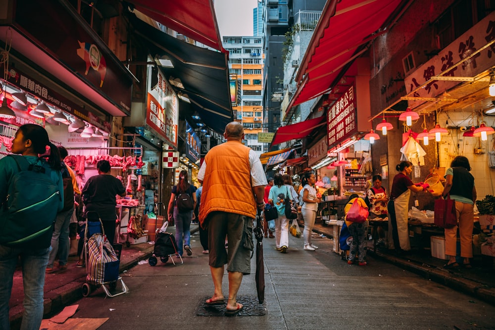 a man walking down a street next to a crowd of people