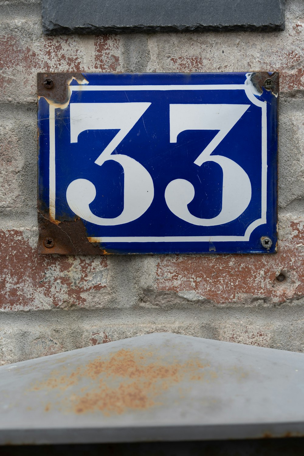 Un letrero azul y blanco en una pared de ladrillo