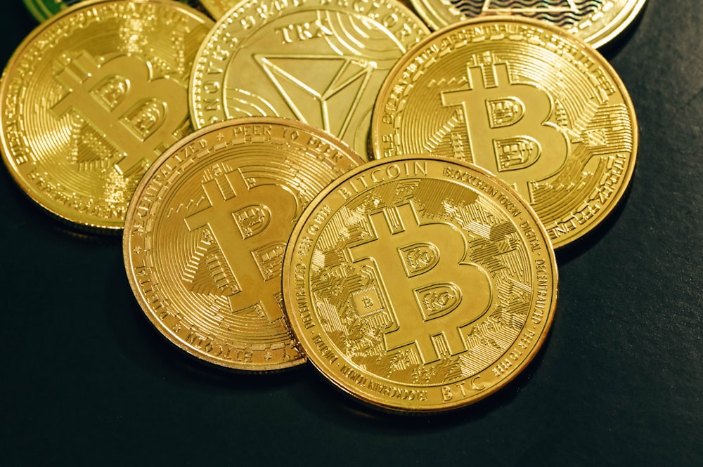 a pile of gold bitcoins sitting on top of a table