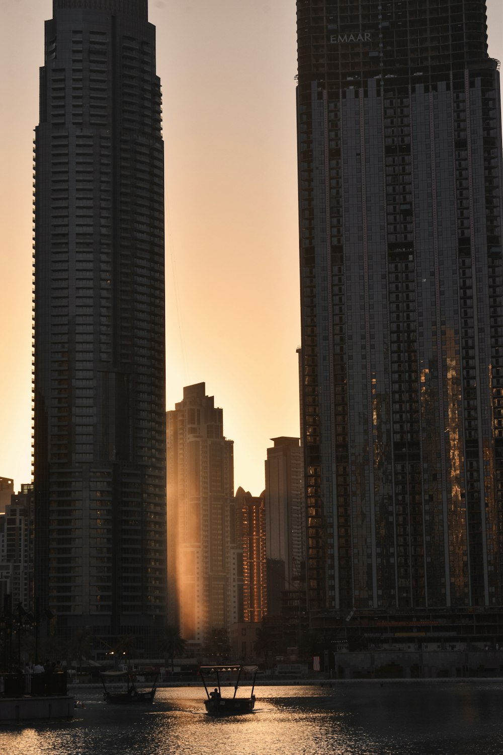 a boat in a body of water in front of tall buildings