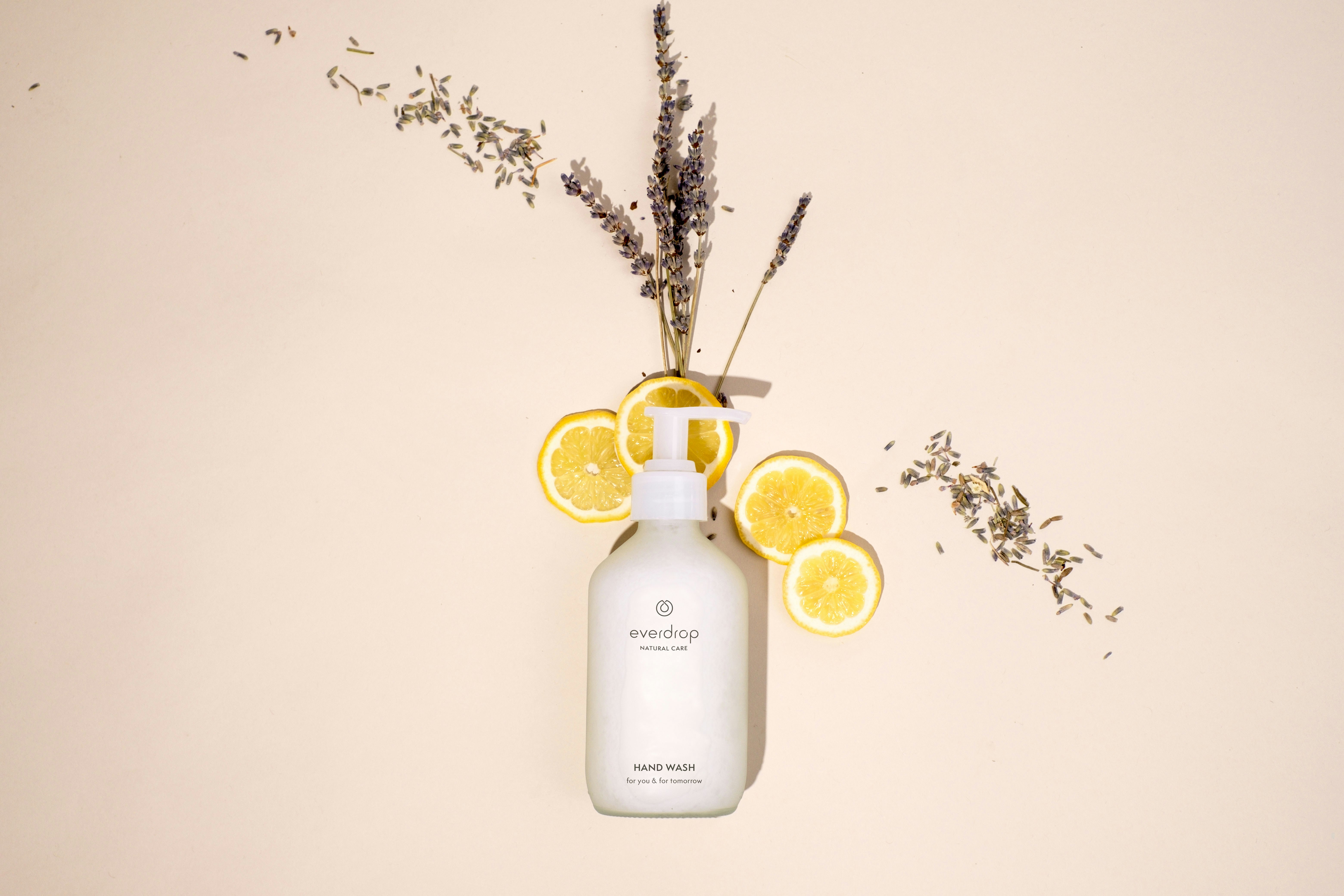 a bottle of lotion sitting next to a bunch of lemons