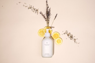 a bottle of lotion sitting next to a bunch of lemons