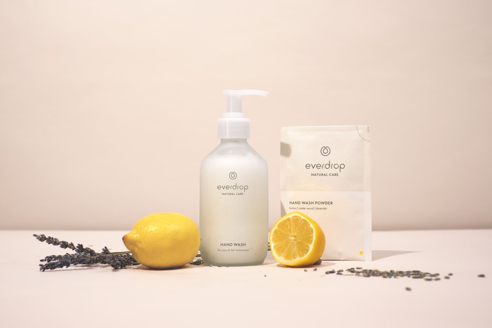 a bottle of soap next to a lemon and lavender