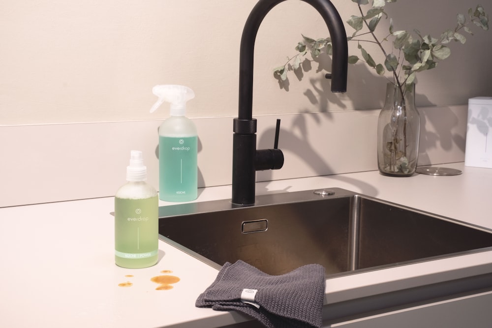 a kitchen sink with a bottle of hand sanitizer next to it