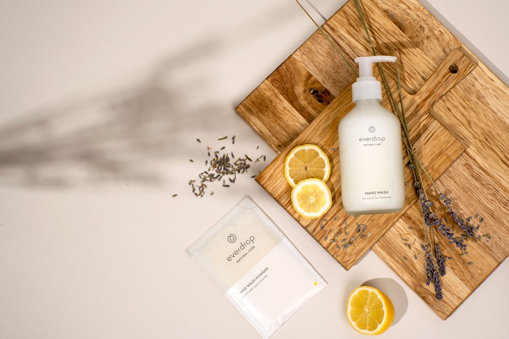 a wooden cutting board topped with a bottle of lotion