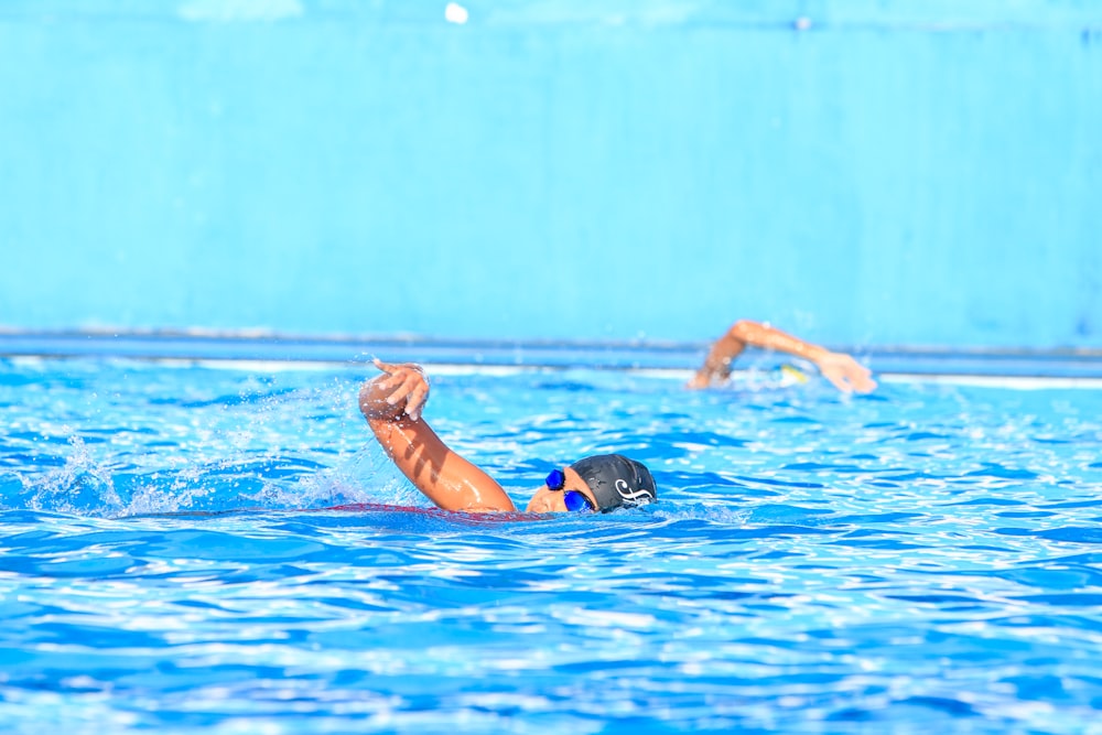 a man swimming in a pool with his arm in the air