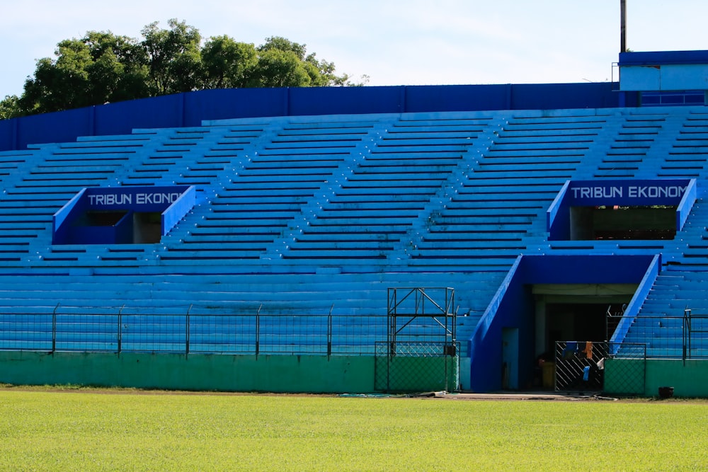 Un gran estadio azul con un campo verde frente a él