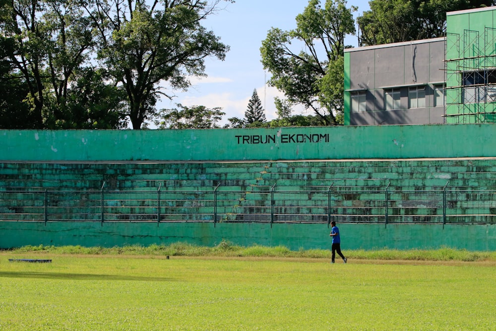 Un hombre caminando por un exuberante campo verde