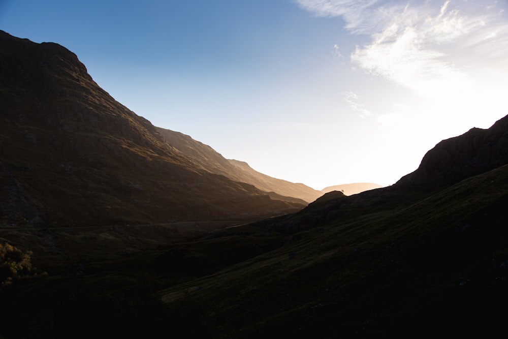 the sun shines brightly in the mountains