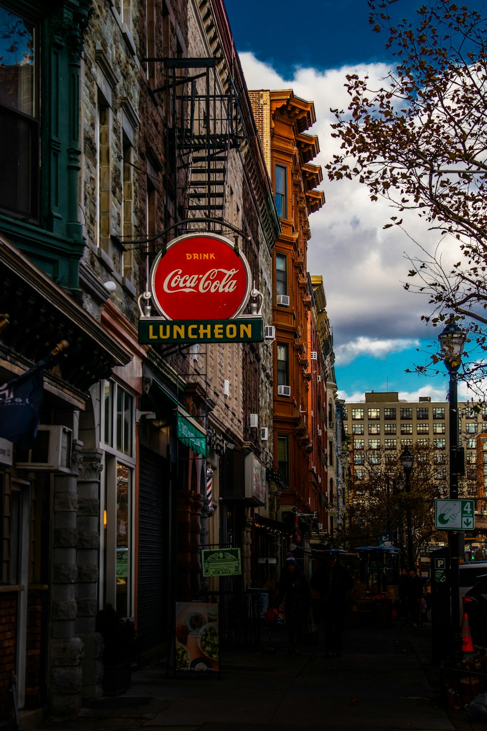 a street lined with tall buildings and a coca cola sign