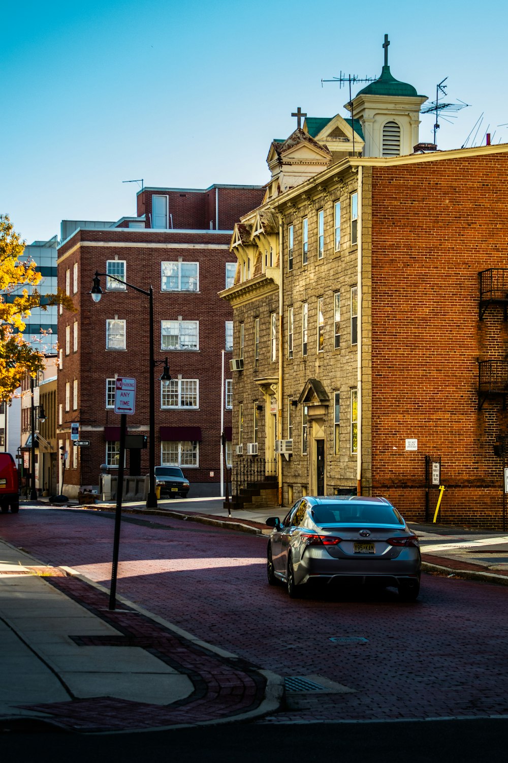 a car driving down a street next to tall buildings