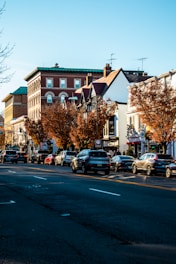 a city street lined with parked cars next to tall buildings