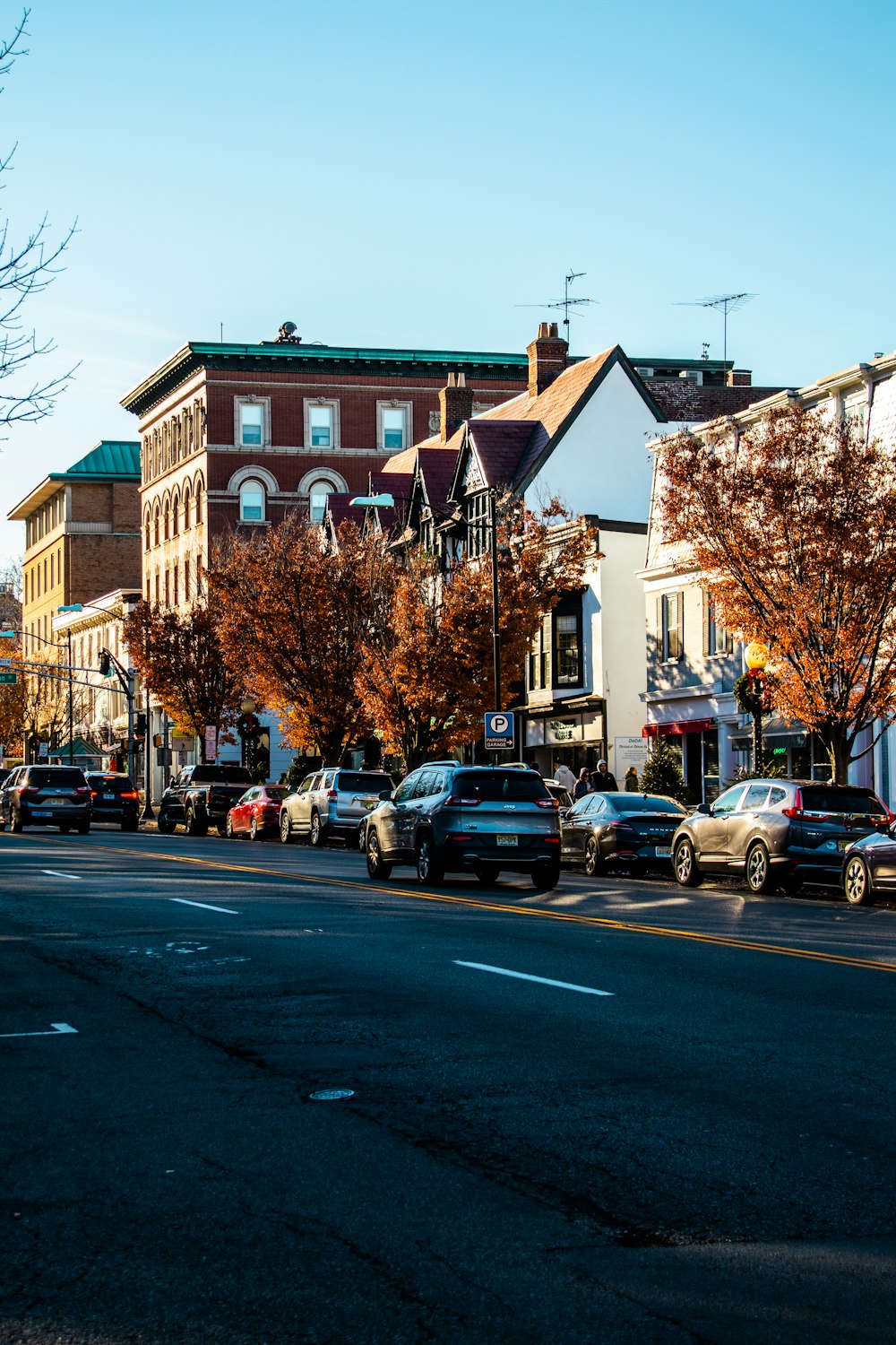 a city street lined with parked cars next to tall buildings