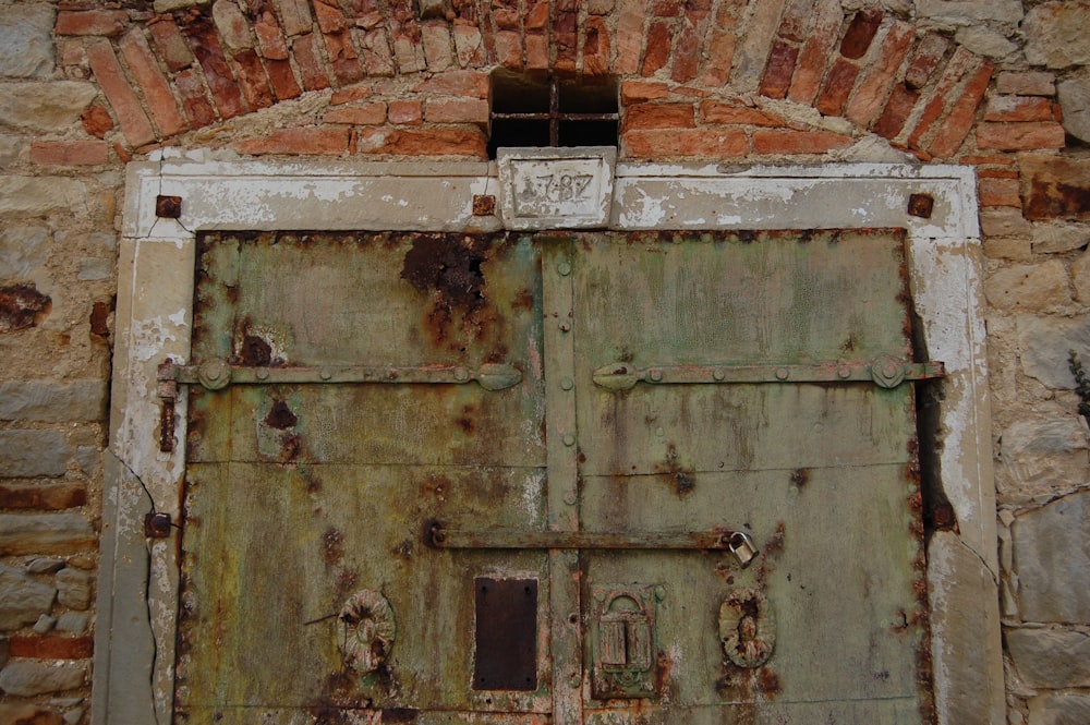 an old door with a window in a brick wall