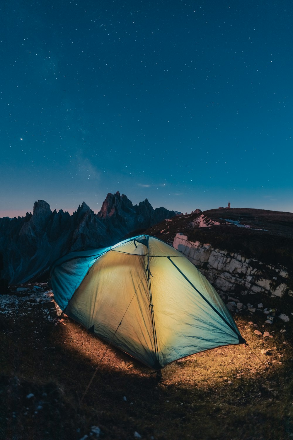 a tent pitched up in the mountains at night